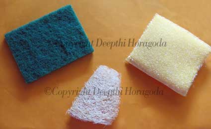 A home-made luffah scouring pad surrounded by synthetic scouring pads